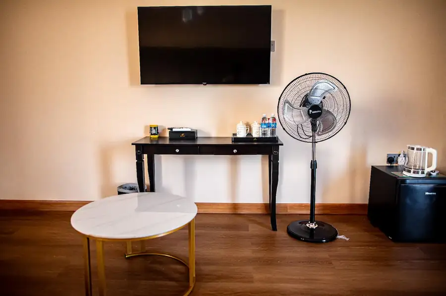 Living space in the Family Room at Turtle Seaweed Resort featuring a flat-screen TV, console table, fan, and mini-fridge.